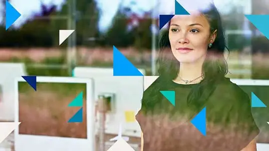 Young woman in work space next to computer looking ahead