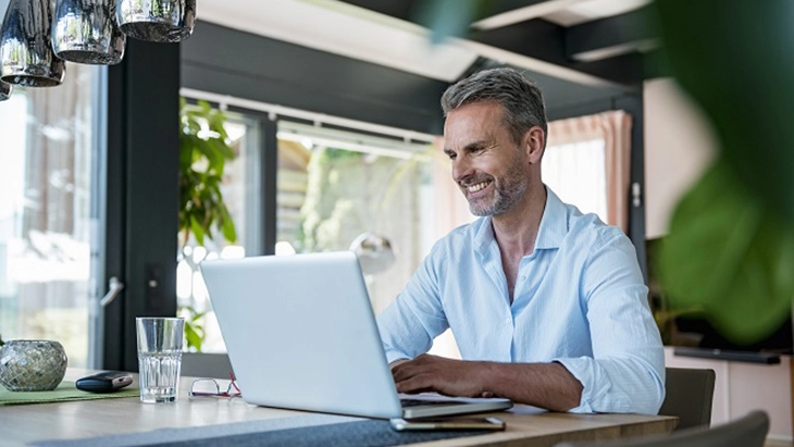 Man working on laptop and smiling