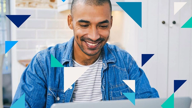 Man smiling and working on laptop