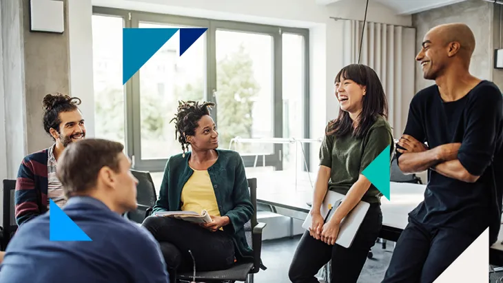 Colleagues laughing and speaking in an office