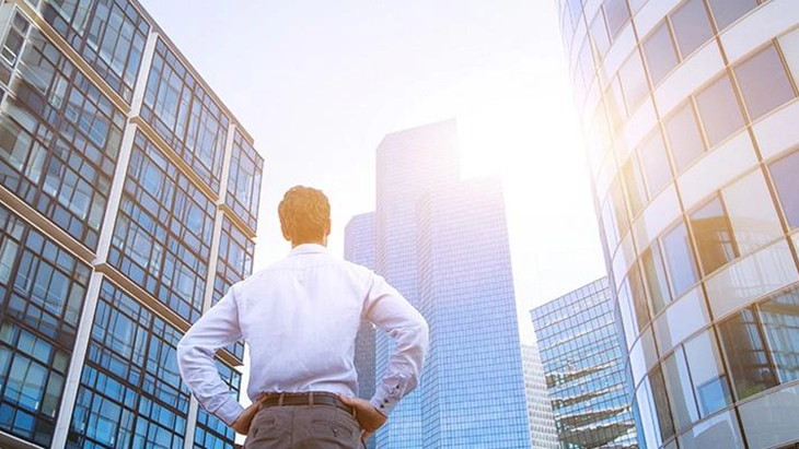 Man looking up at tall buildings