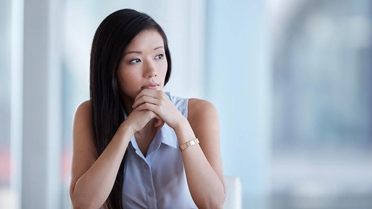 Young woman with chin in hands looking away