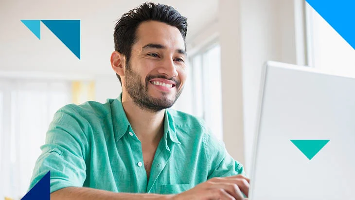 Man smiling and working on laptop